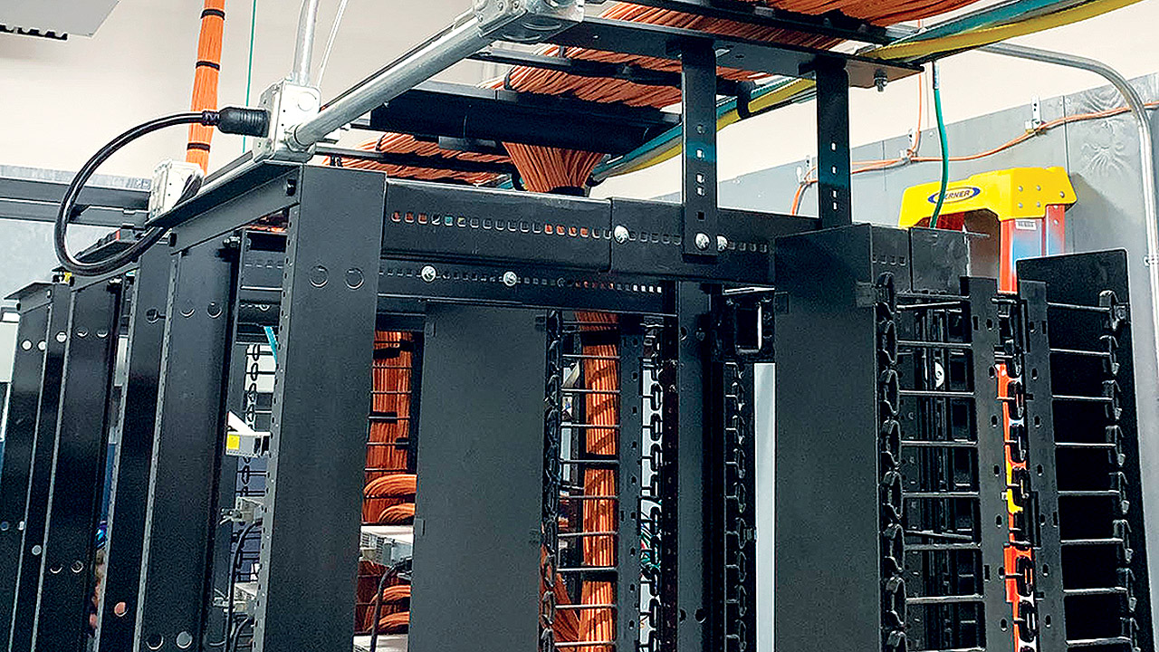 A standards-compliant IT equipment rack and cable pathways in a school district Telecom Room.